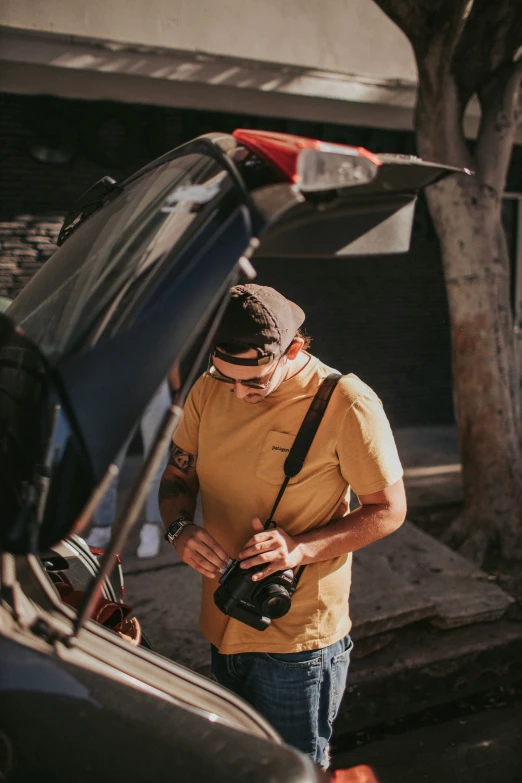 the man is standing next to a parked car