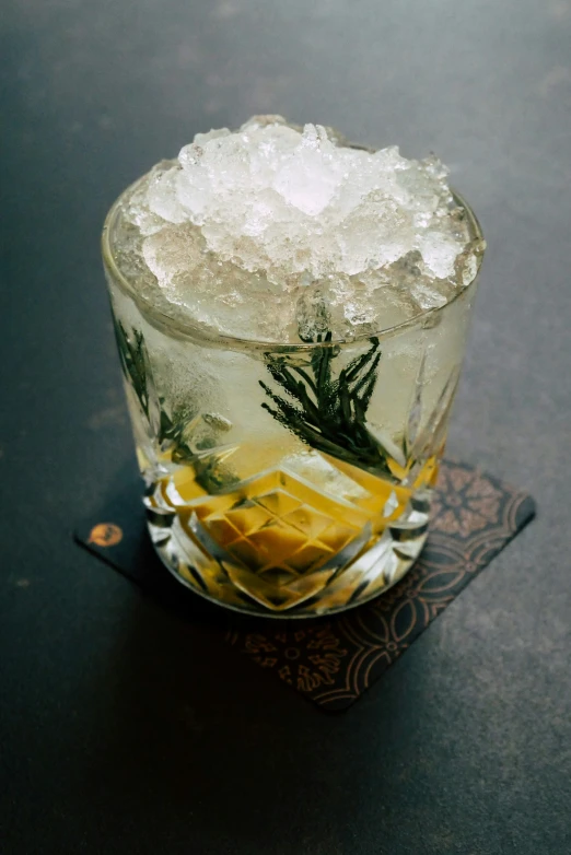 a glass filled with ice next to a bottle