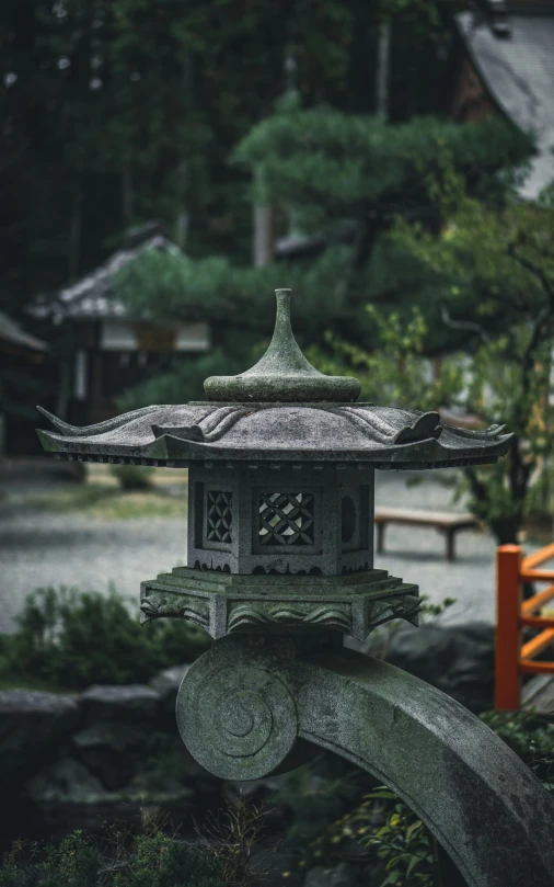 an ornate oriental lantern in the middle of a wooded area