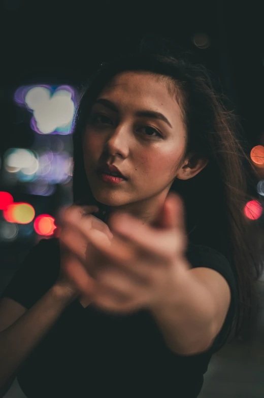 a woman looking at the camera with her hand out