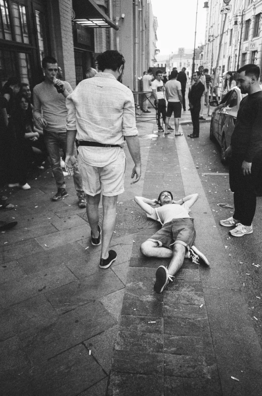 a man laying on the ground near some people