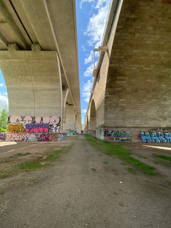 graffiti under a freeway bridge with one lane