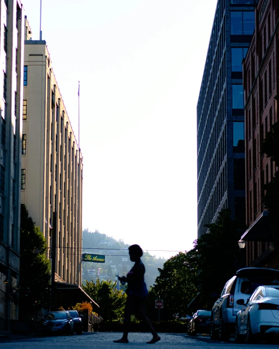 the woman is walking alone in the city with her cell phone