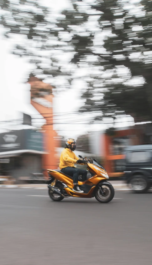 man in yellow coat riding orange and black motorcycle