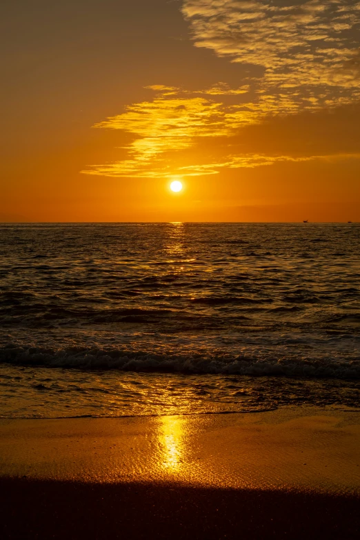 a lone person is standing on the shore as the sun goes down