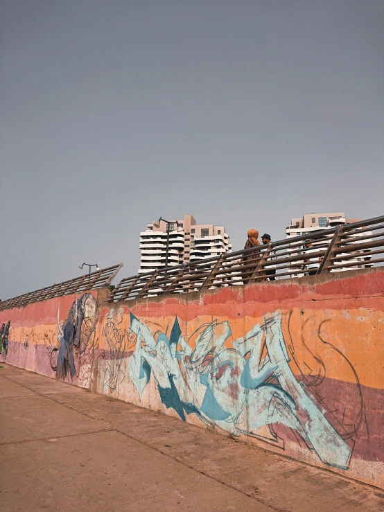 a wall is covered with graffiti under a blue sky