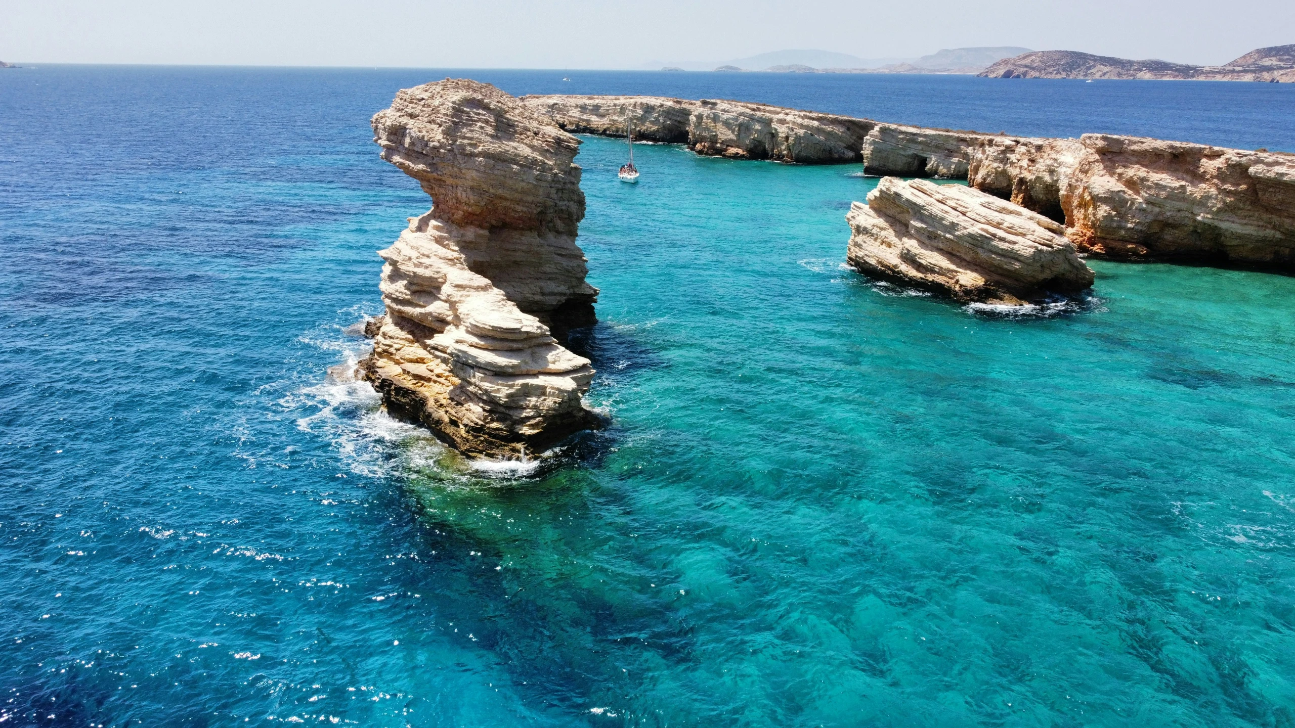 water with some very large rock formations next to the shore