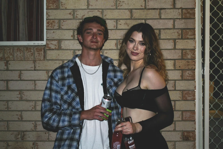 a woman is standing next to a man and he has a glass in front of her