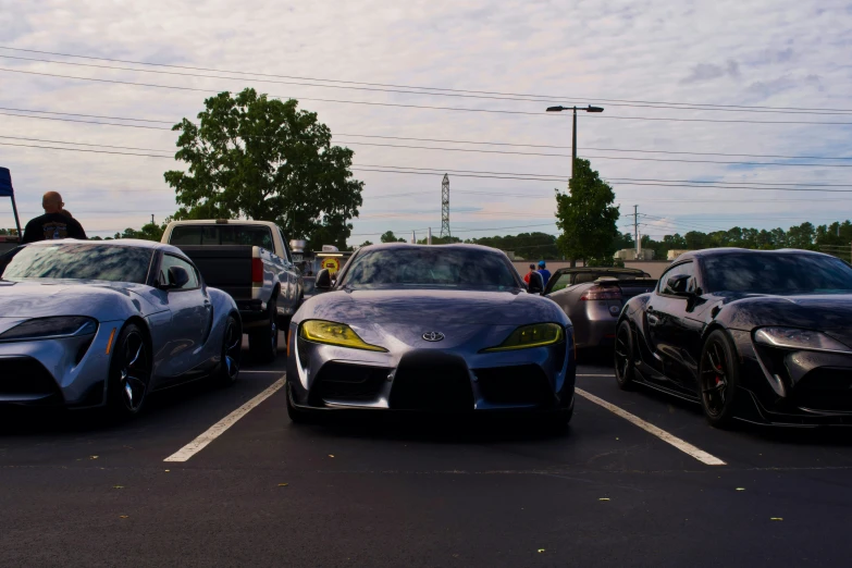three different colored sports cars in parking lot