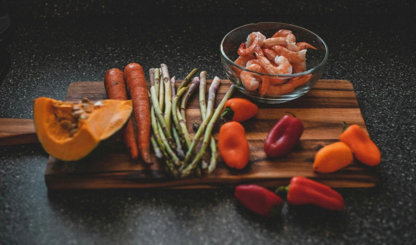 a wood  board with vegetables and some spices