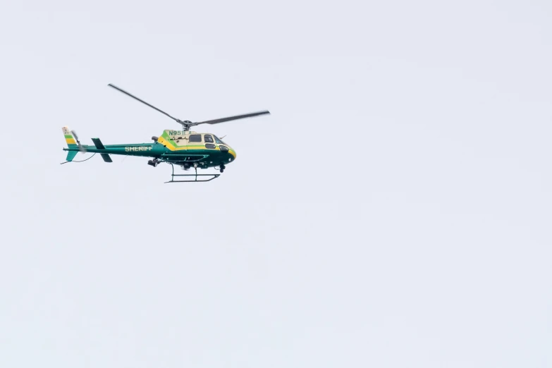 the helicopter is flying through the air on a clear day