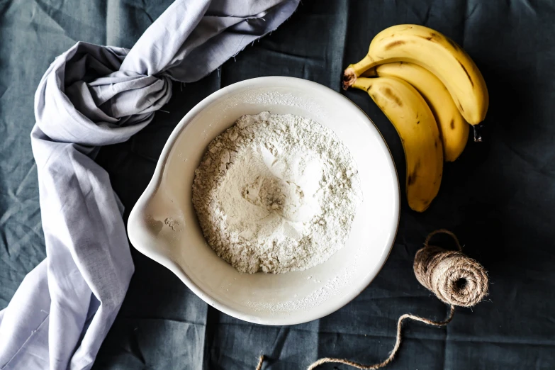 a bowl and some bananas next to a thread