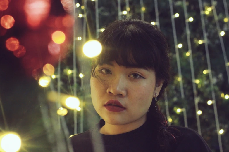 young woman staring at soing with lights in the background