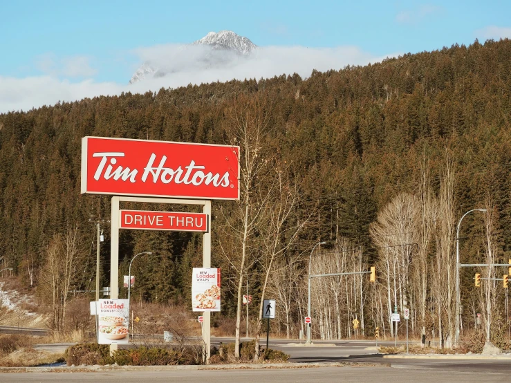 a business sign in front of some mountains and trees