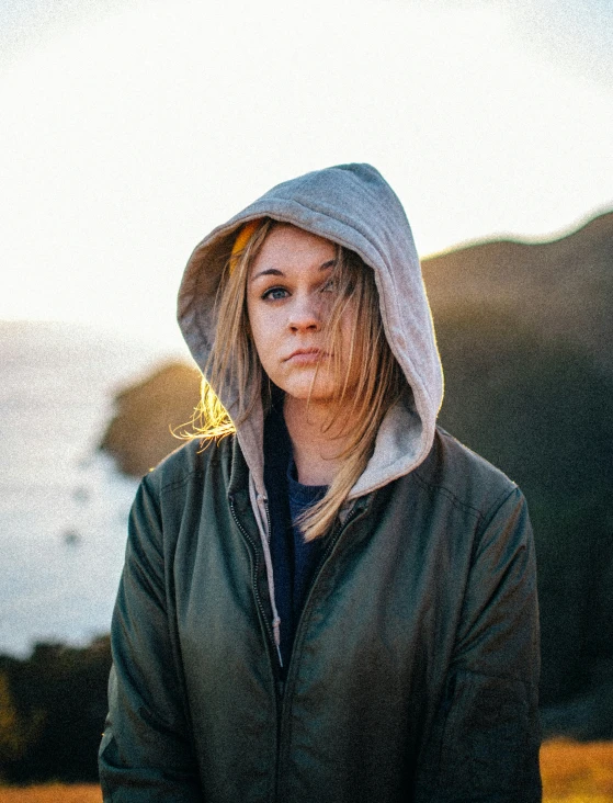 a woman wearing a hoodie looking over her shoulder