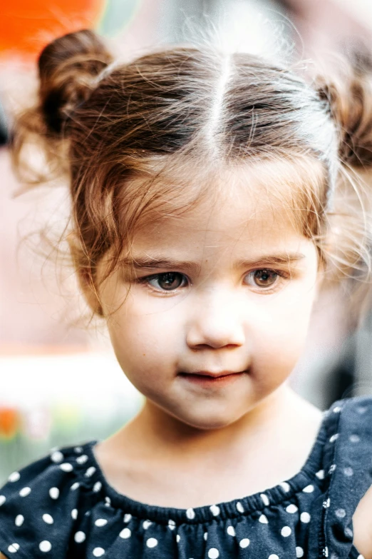 little girl with down and messy hair standing outdoors