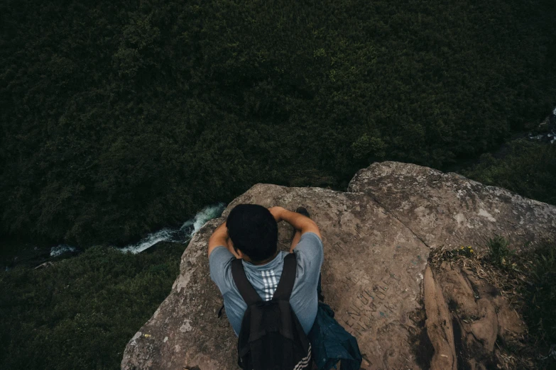 a man on top of a hill looking down at the ground