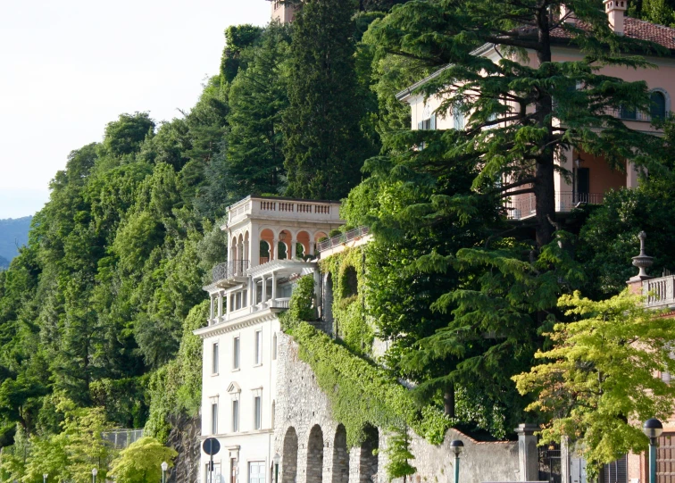 a tall white building with green plants growing on the top