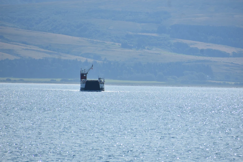 a boat floats down the river as a lone animal stands on the edge