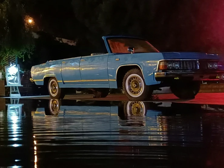 a blue chevrolet impcador sitting on the side of a street