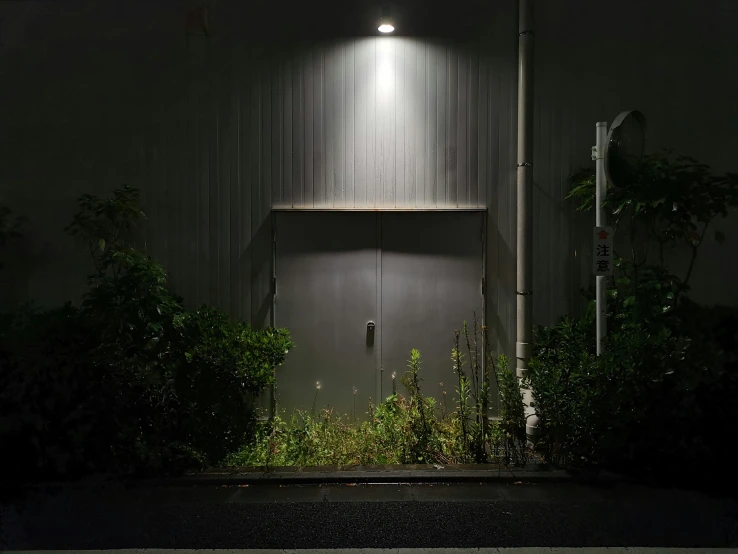 a dark room containing an exit door with a sign