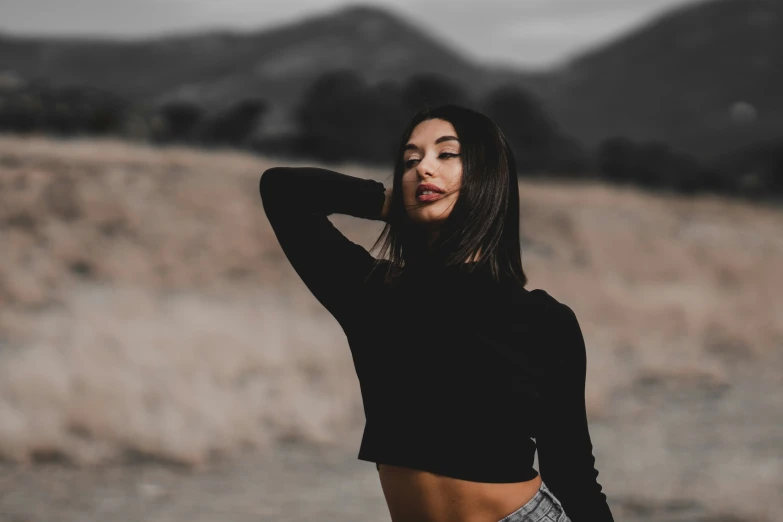 a woman in black shirt posing in field