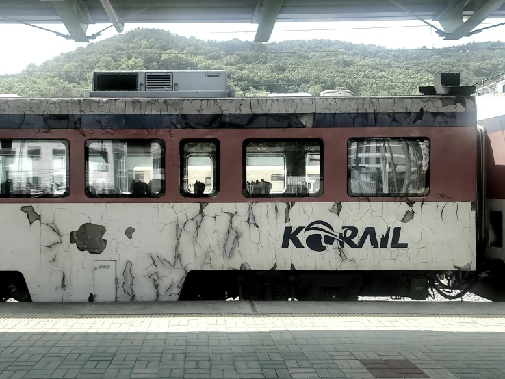 old train stopped next to two separate parking areas