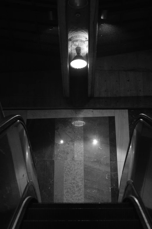 an escalator with a light above it in a room