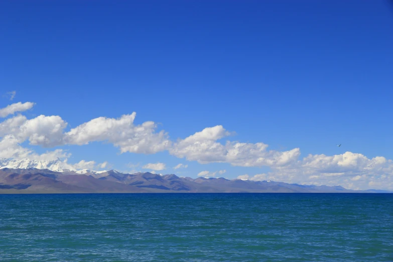 a plane flying in the sky near the water