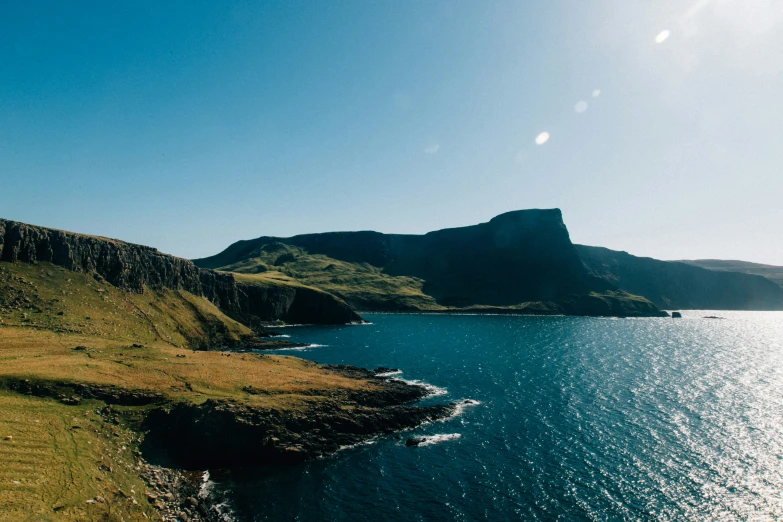 the mountain next to the water looks like it's falling apart