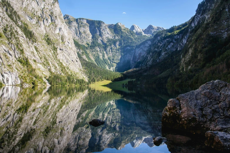 the trees and mountains have been reflected in the still water of the lake