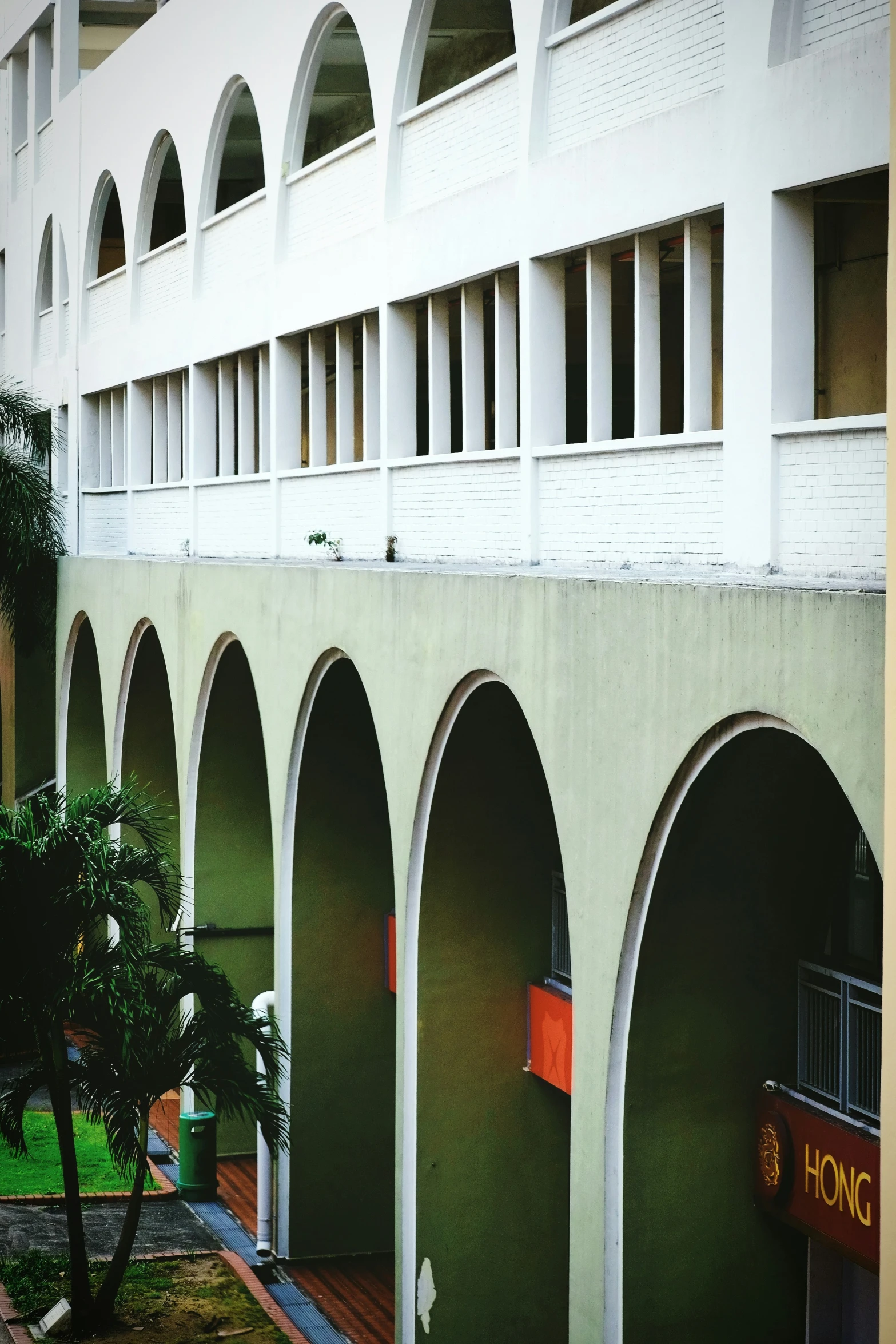 an empty courtyard with large arches between two buildings