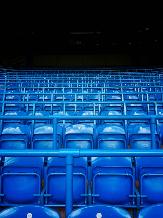 blue seats are set up in an empty stadium