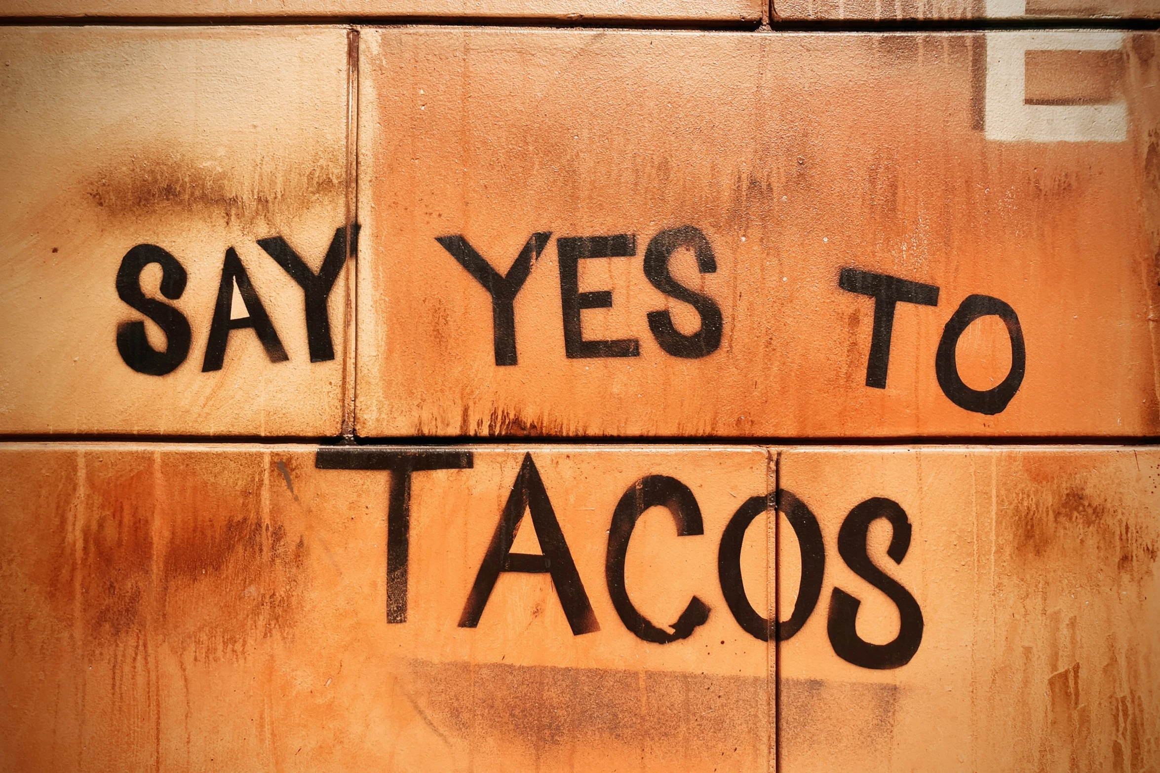 two letters written on wooden planks which say'say yes to tacos '