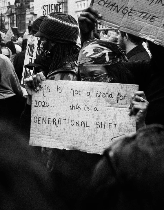 a protest in black and white showing a crowd holding up signs