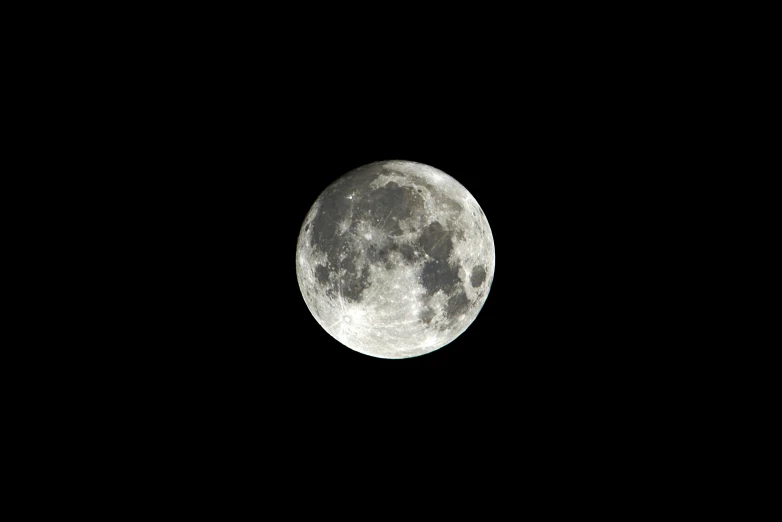 the full moon in the dark sky seen through the telescope lens