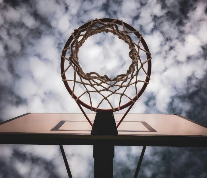 a basketball hoop in the midst of a cloudy sky