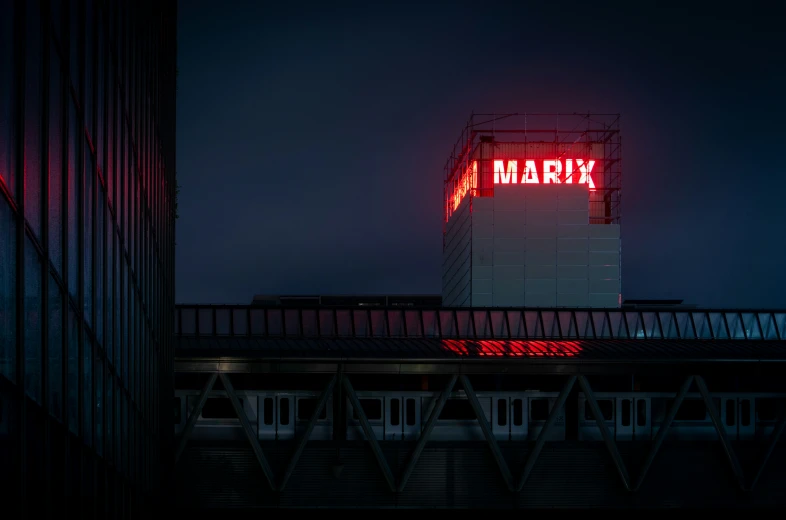 a red neon sign on the roof of an office building