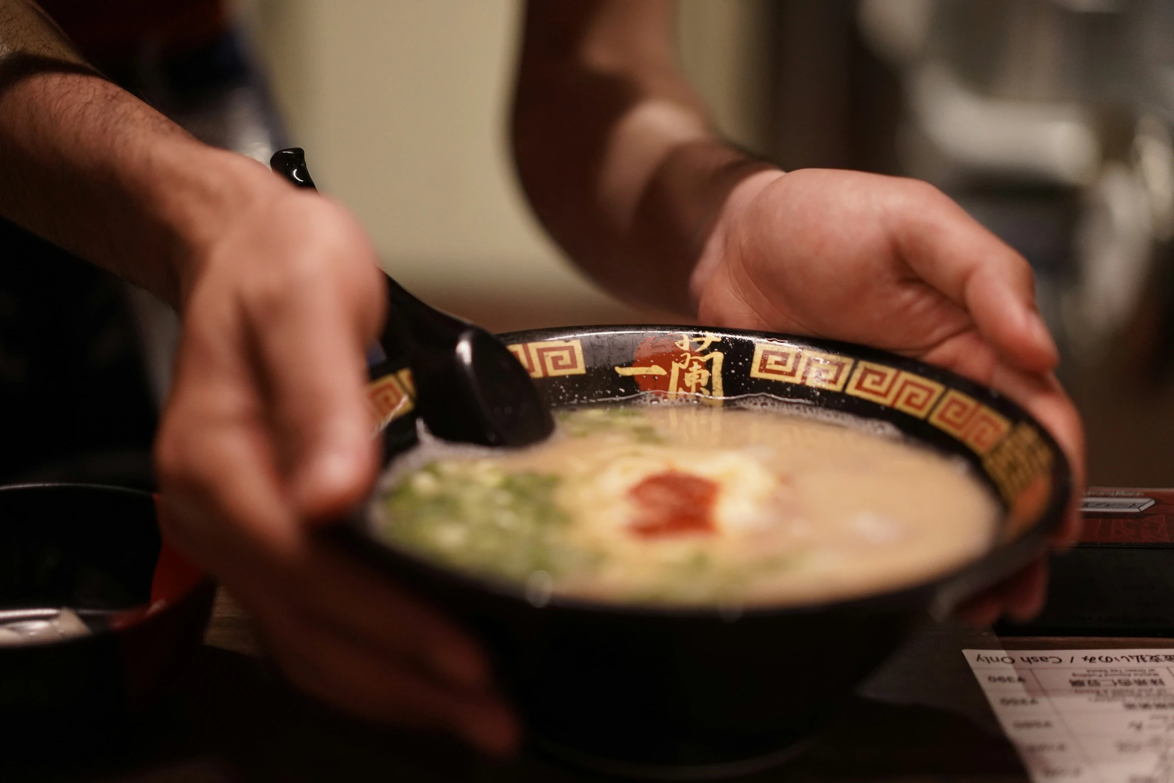 someone getting soup from a bowl of food in a bowl