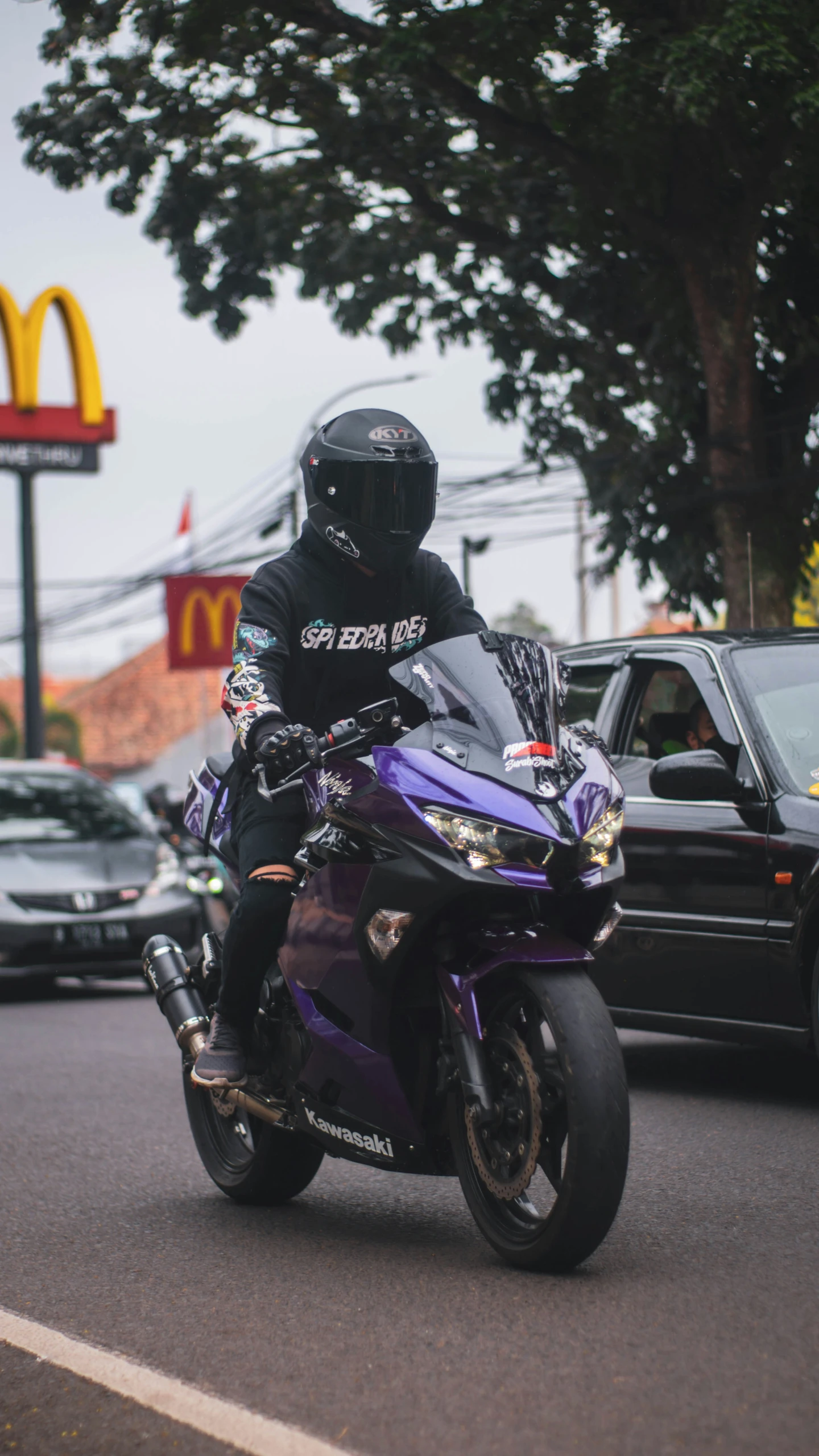 a motorcycle racer rides his bike down the street