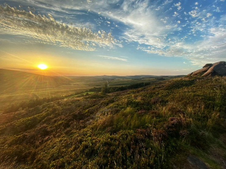 a beautiful sunset on the hills, with the sun just beginning to break up