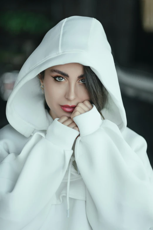 an attractive young woman wearing a white hoodie