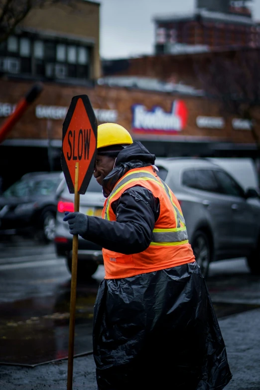 there is a person walking on the street holding a sign