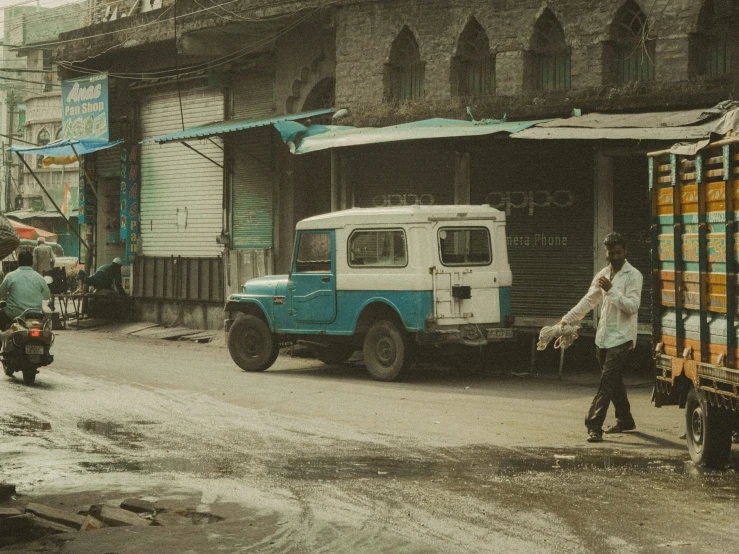 a man riding a bicycle next to a truck and building