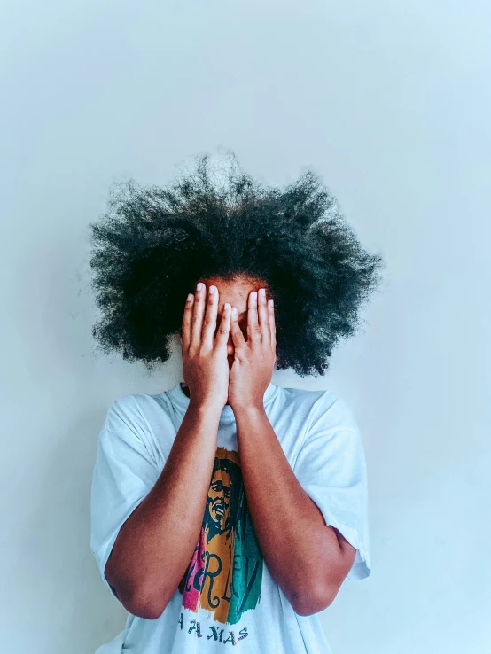 a black woman with afro hair covering her eyes