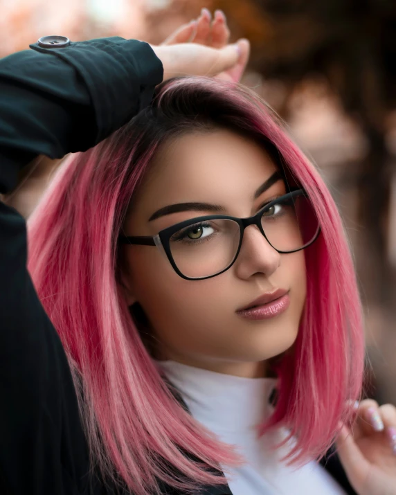 a woman with pink hair and glasses posing