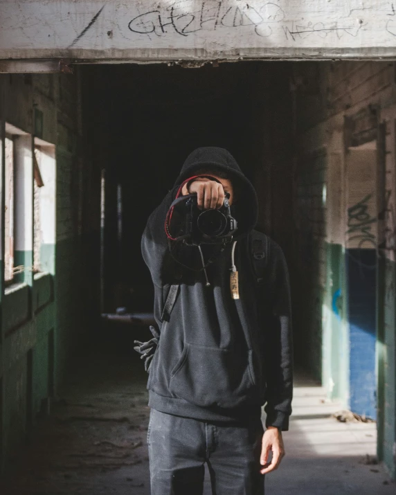 a man standing on the street while wearing a hoodie