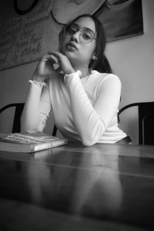 black and white po of woman sitting at table