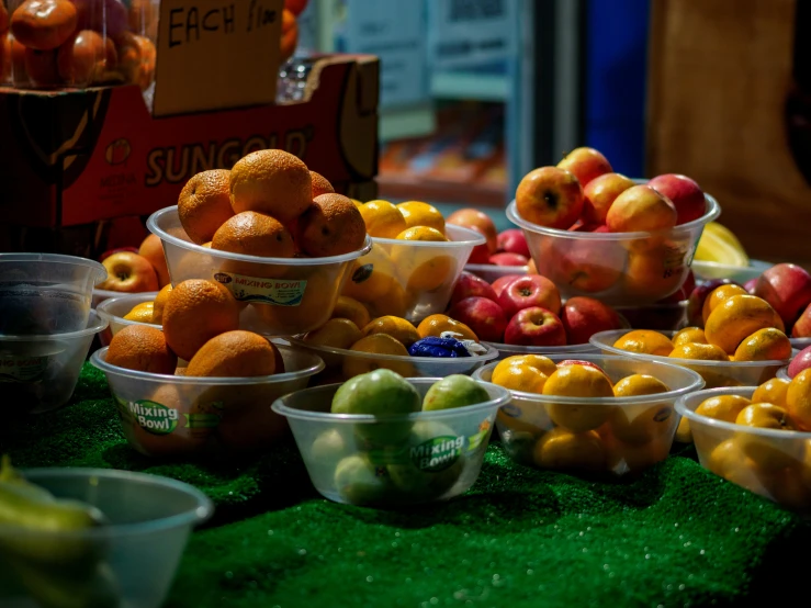 a fruit stand with lots of colorful oranges and apples