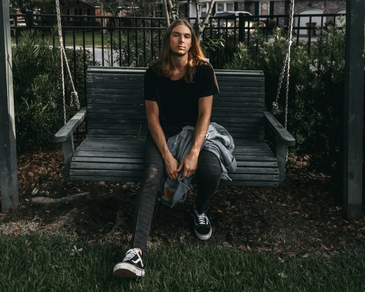 a man sits on the porch swing in front of the house